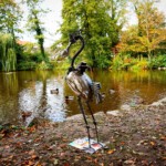 Skulptur Reiher, Ansicht von hinten links, vor einem See